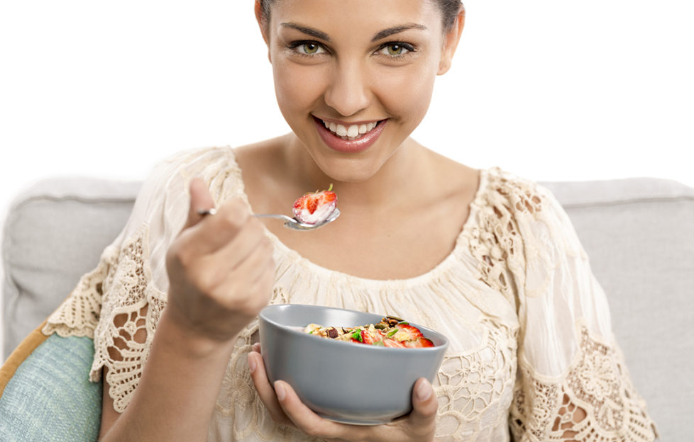 Beautiful happy woman at home eating a healthy bowl