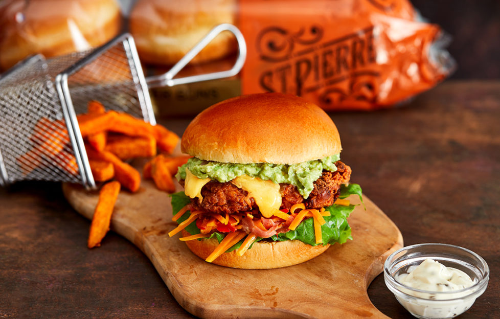 Gourmet burger in brioche bun with orange pumpkin slaw and sweet potato fries