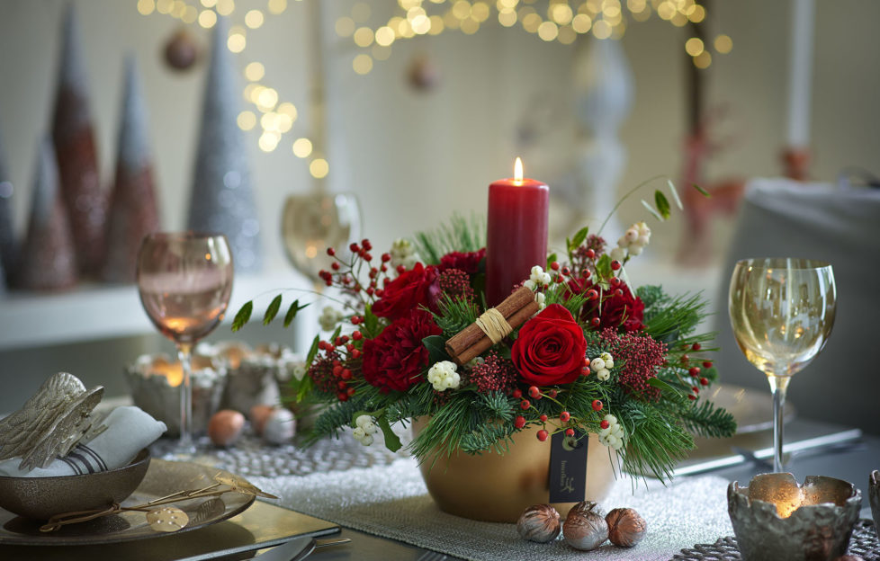 Flowers in a candle arrangement on a Christmas table