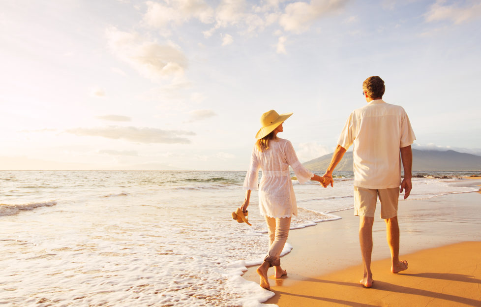 Happy Romantic Middle Aged Couple Enjoying Beautiful Sunset Walk on the Beach. Travel Vacation Retirement Lifestyle Concept