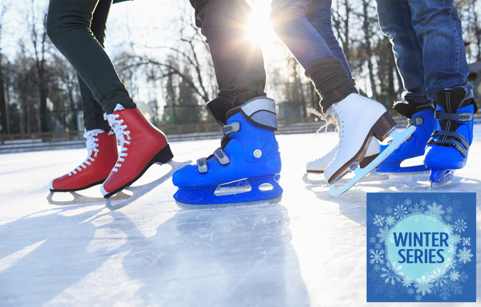 Feet of 4 ice skaters on lake, figure skating boots and ice hockey boots, sun through trees behind