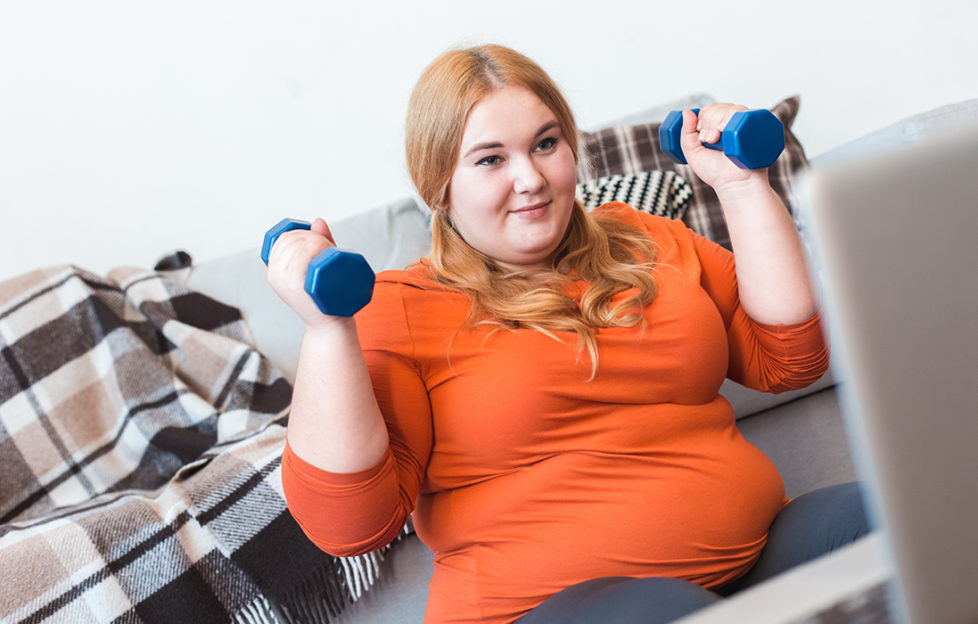 Chubby woman lifting dumbbells to be healthierimprove fitness