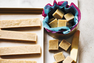 Fudge cut into bars and cubes, some in a tissue lined gift box