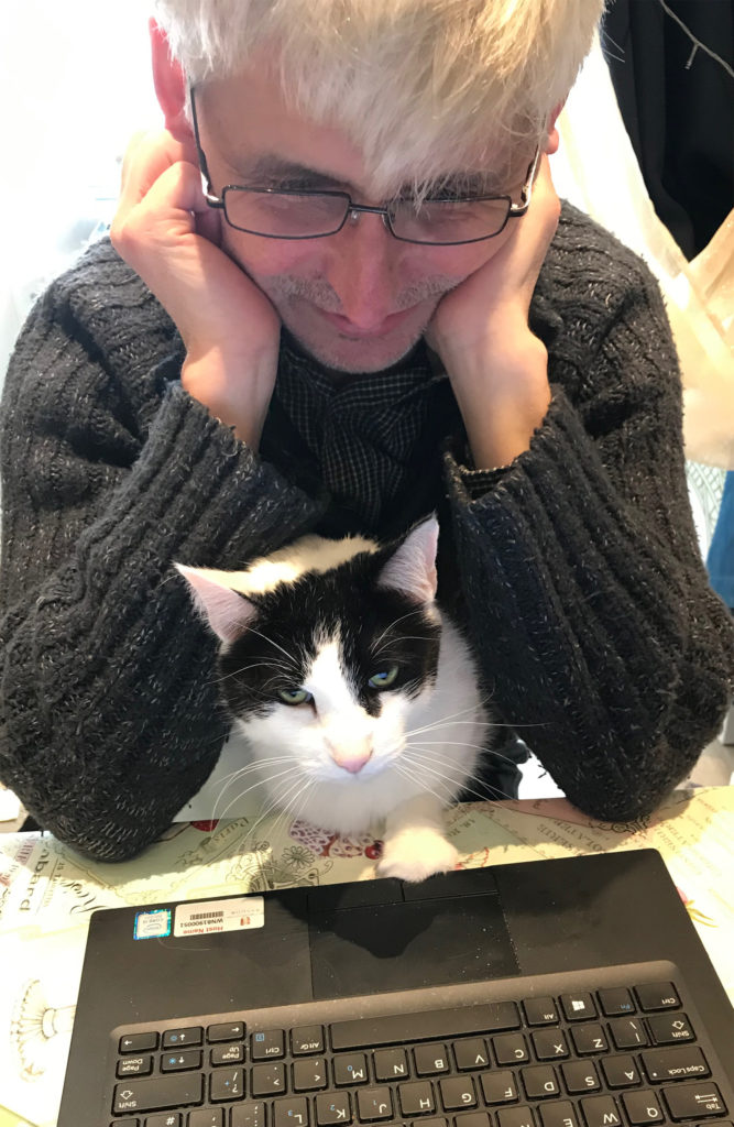 Man trying to work with cat on his lap