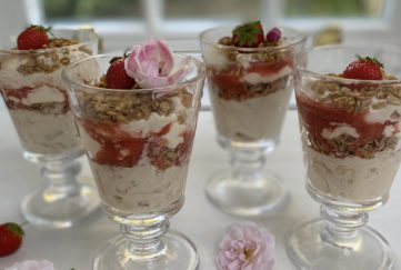 4 sundae glasses with rhubarb fool topped with pink flowers