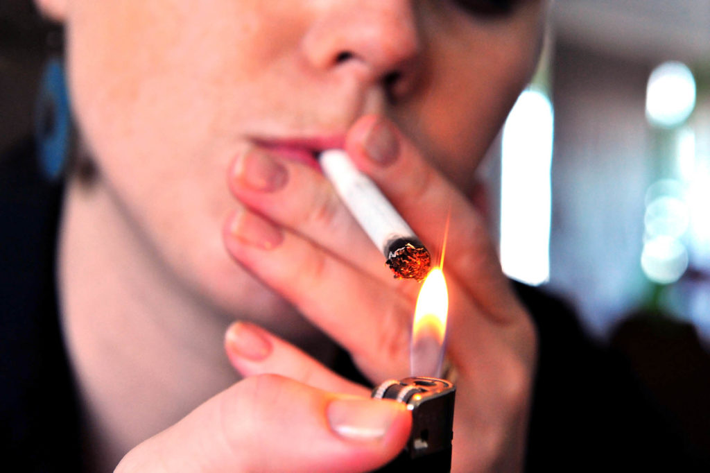 Concept photo of a woman smoking a cigarette.; 