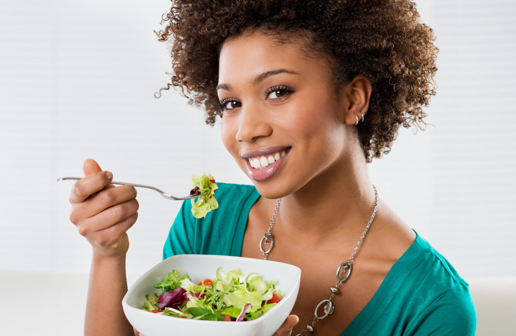 Close-up Of Beautiful African American Woman Eating Salad At Home; 