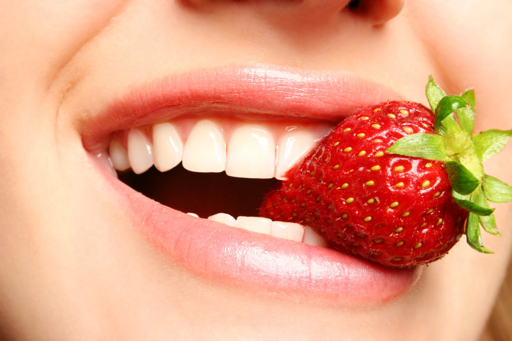 beautiful lips holding a strawberry; 