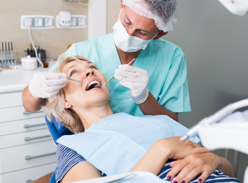 Woman in dental chair with dentist working