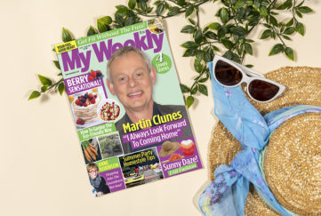 My Weekly latest issue with Martin Clunes and summer berry cookery. Styled shot with straw hat, blue scarf, sunglasses and ivy branches