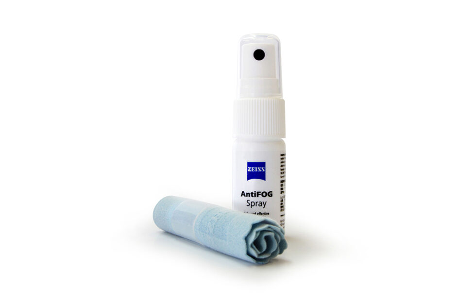 Bottle of anti fog spray and blue cloth rolled up