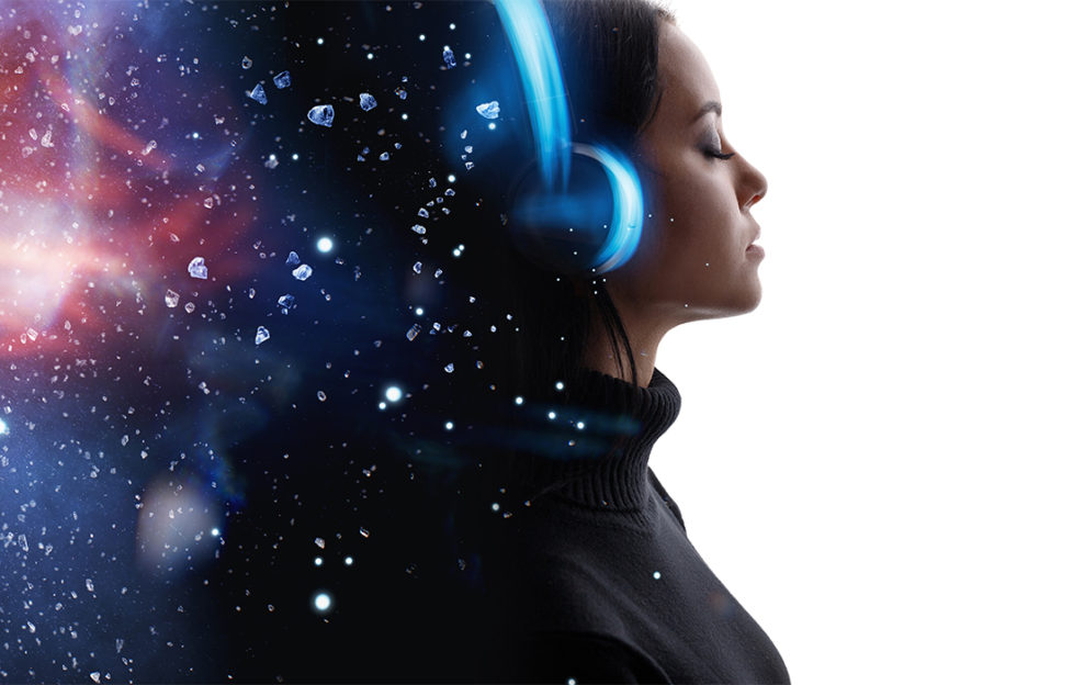 Woman with headphones meditating, stars in space in her mind