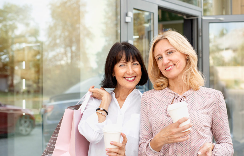 Two mature women having fun while doing shopping and drinking coffee. Pastime concept of mature people;