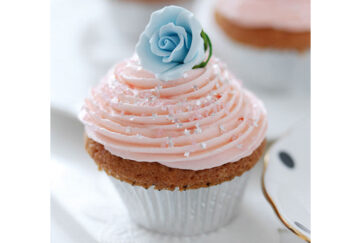 Cupcake with swirl of pink icing and blue sugar rose, friendship cake