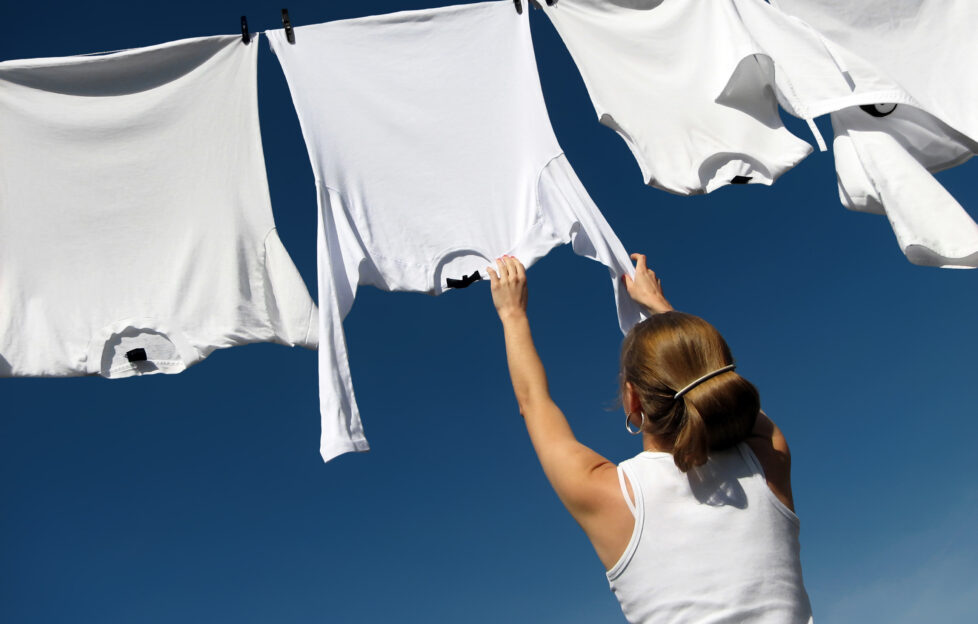 Girl, blue sky and white laundry;