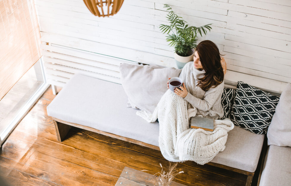 Beautiful woman enjoying cup of tea in her cosy house;