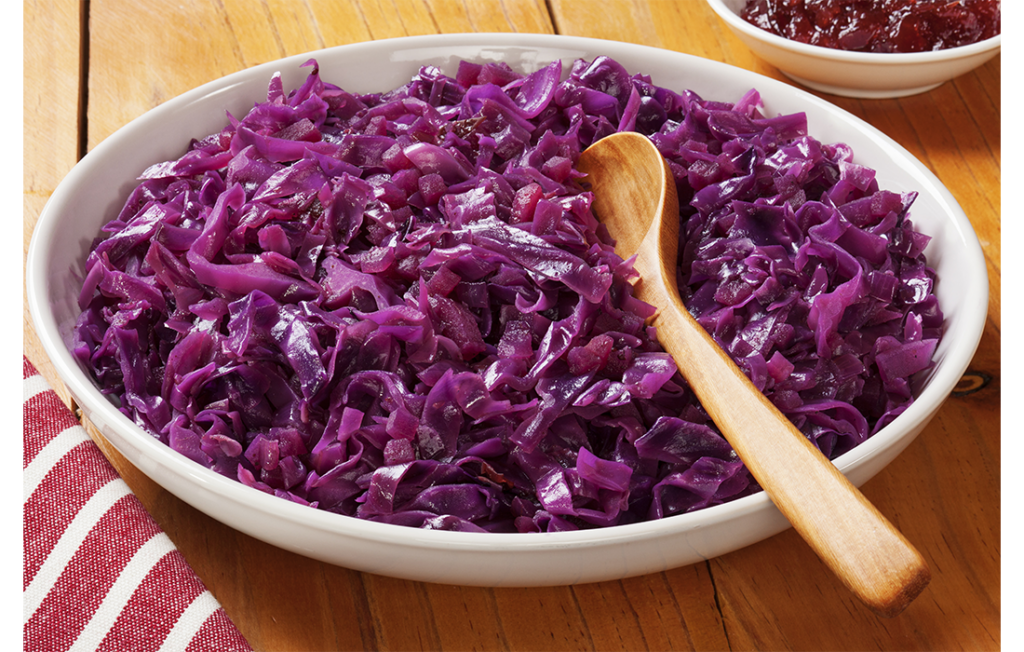 Red cabbage in big bowl with wooden spoon