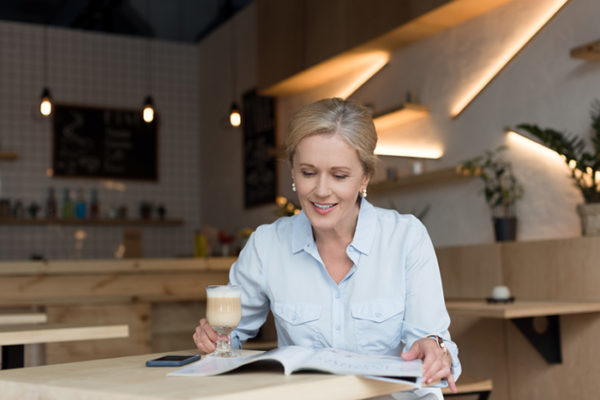 woman reading No,1 magazine in coffee shop