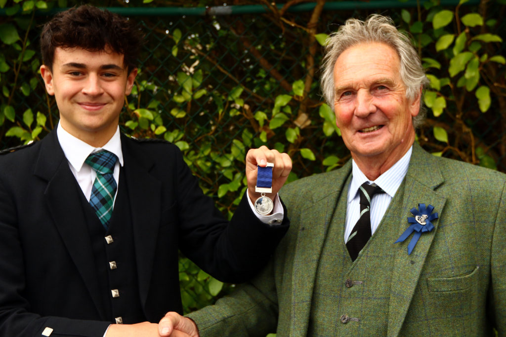 Ruaridh Brown won the U22 MacGregor Memorial Piobaireachd and was presented with his medal by piping steward Jamie Mellor.