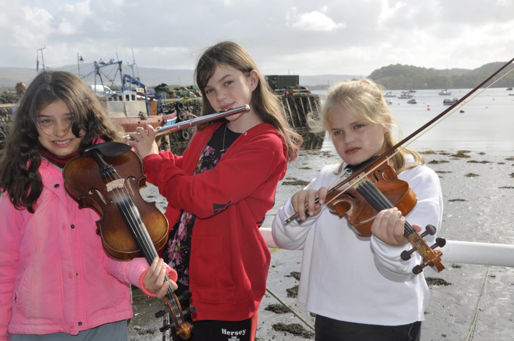 Tarbert folk group Na Smearaich took time out to practice on Tobermory seafront during the 2019 Mull Mod. From left is Daria Deravyankin, Sarah Kirk and Aimee Burnett.