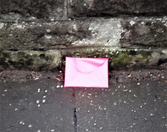 Was this pink envelope dropped, thrown away, or deliberately posed?