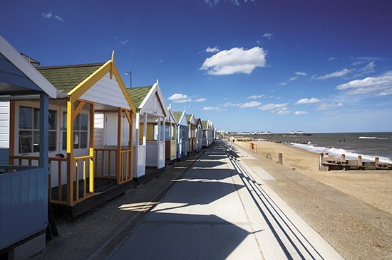 Southwold beach huts & pier on a summers day on the Suffolk Coast.