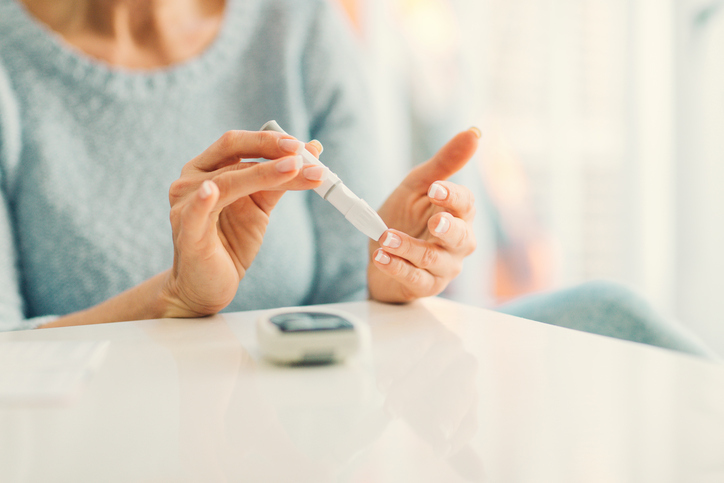 Diabetes and your eyes Mature woman doing blood sugar test at home in a living room. Selective focus to her finger. Diabeties and eyes