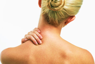 Blond women with neck ache. lond women with neck and backache rubbing area to ease pain