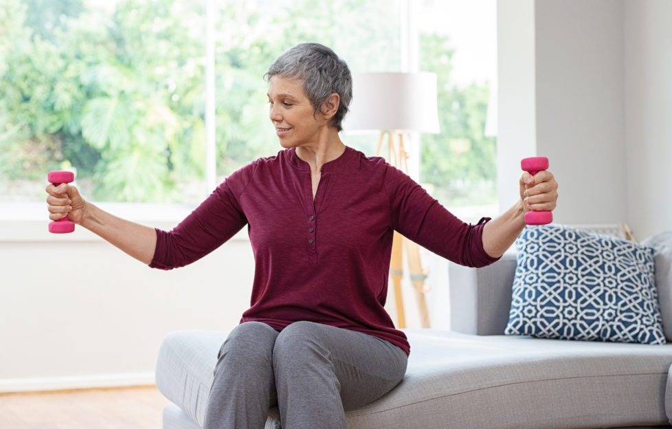 Lady lifting dumbbells as she exercises at home