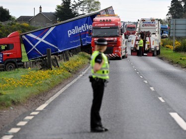 Police control traffic whilst the lorry is salvaged