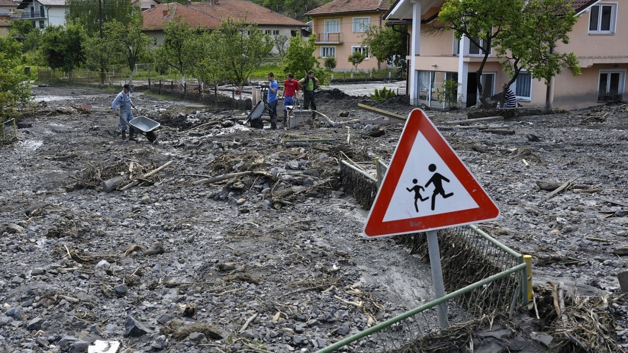 Residents clean streets of mud and rubble after a landslide at the village of Topcic Polje, near the Bosnian town of Zenica, 90 kilometers north of Sarajevo