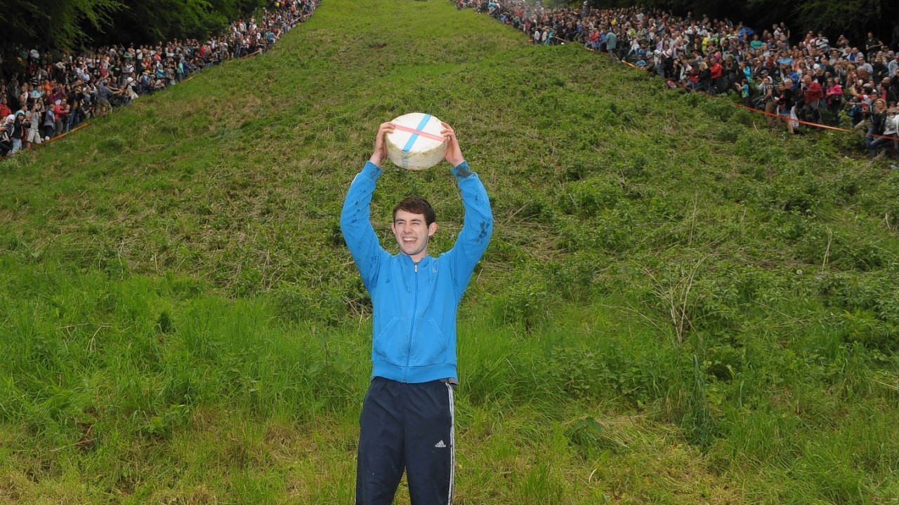 Josh Shepherd, 19, from Brockworth, celebrates winning the Men's Downhill race in the Cheese Rolling on Cooper's Hill race near Brockworth, Gloucestershire