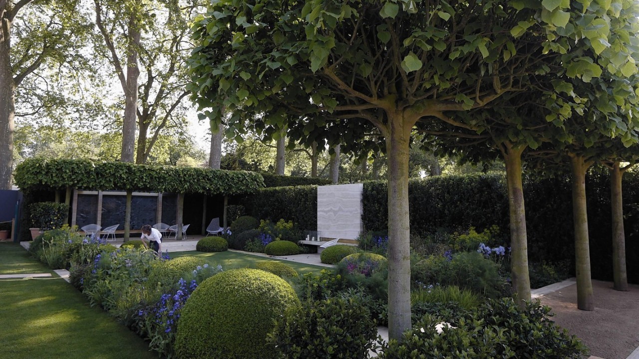 A gardener works in a show garden called 'The Telegraph Garden', designed by Tommaso del Buono and Paul Gazerwitz, at the Chelsea Flower Show