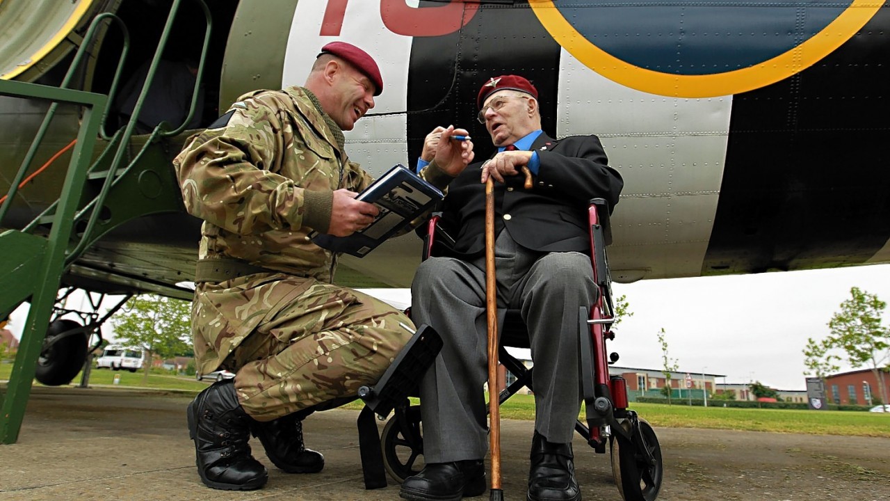 Sergeant Jim Kilbride of 4 Para with veteran Fred Milward, aged 90, during a visit by veterans of the 9th (Eastern and Home Counties) Parachute Battalion to the Merville Barracks home of the 16 Air Assault Brigade to watch current paratroopers ground training ahead of a commemorative parachute jump in Normandy on June 5th