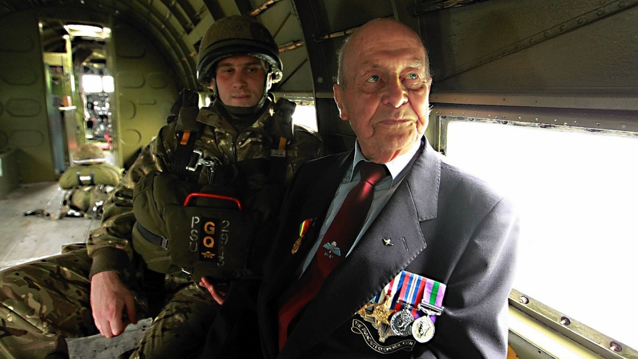 Corp Nick Quinn of 2 Para with veteran Jeff Pattinson, aged 90,  during a visit by veterans of the 9th (Eastern and Home Counties) Parachute Battalion to the Merville Barracks home of the 16 Air Assault Brigade to watch current paratroopers ground training ahead of a commemorative parachute jump in Normandy