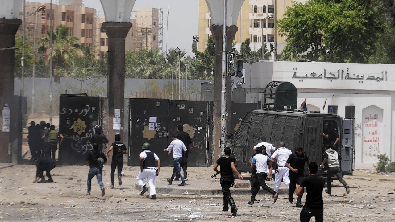 Egyptian security forces run into a student housing area of Al-Azhar University during clashes with student protesters in Cairo, Egypt,