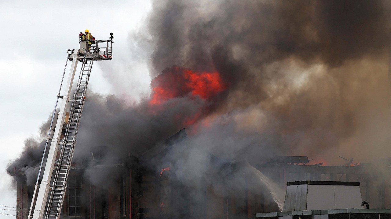 Fire fighters at the scene of a fire at a former school on Broomloan Road in Govan, Glasgow