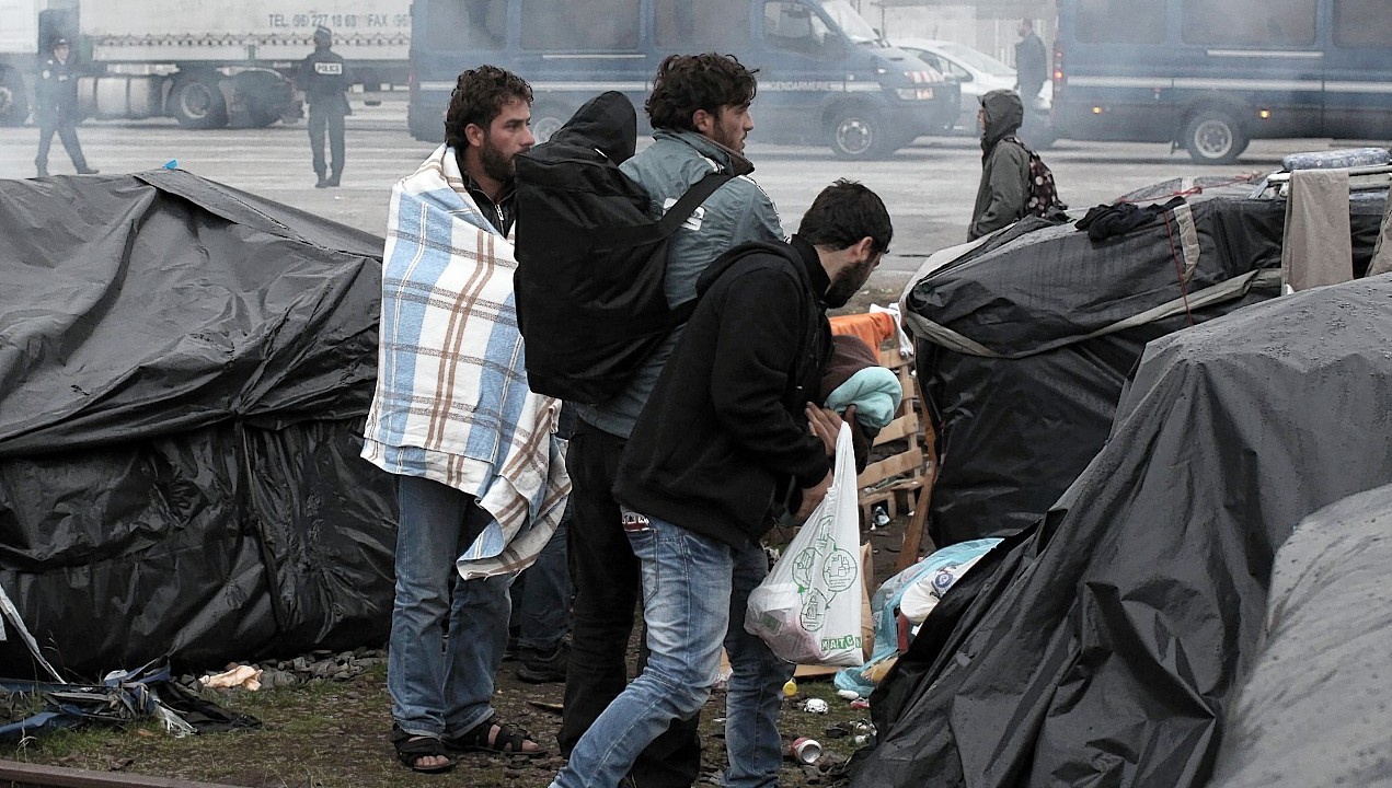 Migrants try to salvage their belongings as French authorities start to clear out makeshift camps housing hundreds of illegal migrants from Syria, Afghanistan and Africa in the English Channel port city of Calais, northern France, Wednesday, May 28, 2014. French media reports say that Calais authorities wanted the camps cleared out because of a scabies epidemic.
