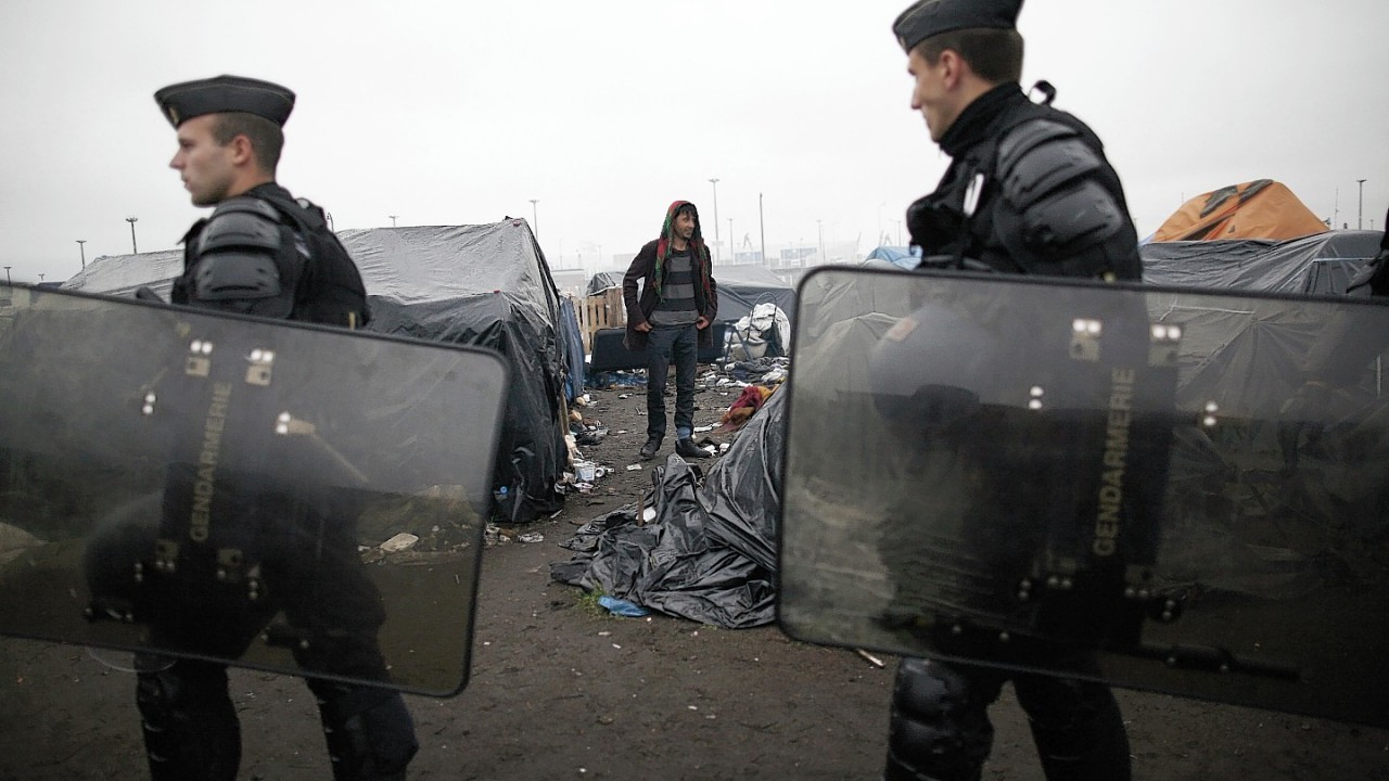 Police officers take positions in a makeshift camp after French authorities started to clear out camps in the English Channel port city of Calais, northern France, housing hundreds of illegal migrants from Syria, Afghanistan and Africa, Wednesday, May 28, 2014. French media reports say that Calais authorities wanted the camps cleared out because of a scabies epidemic.