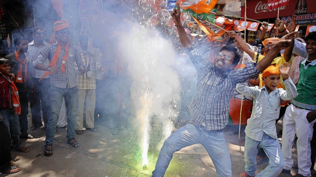 Bharatiya Janata Party (BJP) supporters dance and burst firecrackers to celebrate the news of early election result trends in Allahabad, in the northern Indian state of Uttar Pradesh