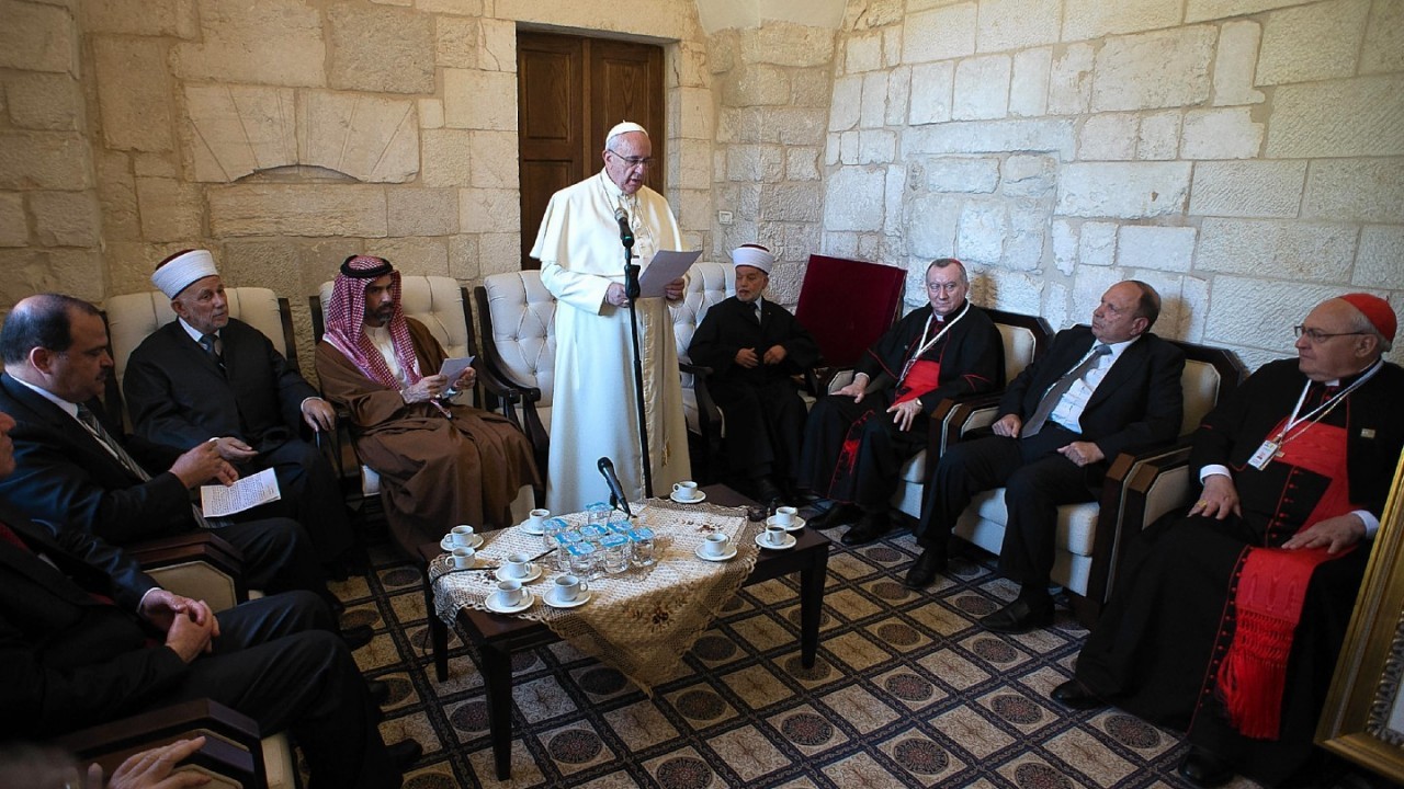 In this photo provided by the Vatican newspaper L'Osservatore Romano, Pope Francis reads his message on the occasion of his meeting with the Mufti of Jerusalem Muhammad Ahmad Hussein, fourth from right, during their meeting in Jerusalem