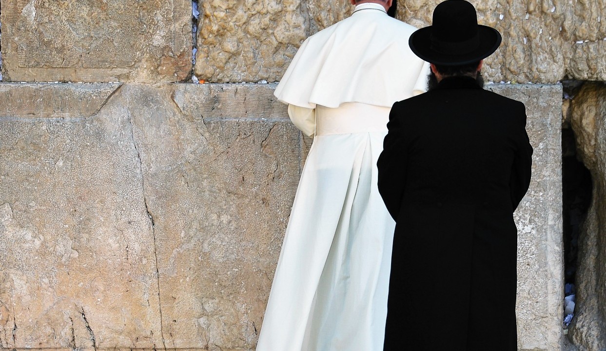 Pope Francis prays at the Western Wall, the holiest place where Jews can pray, as an unidentified Rabbi looks at him, in the old city of Jerusalem