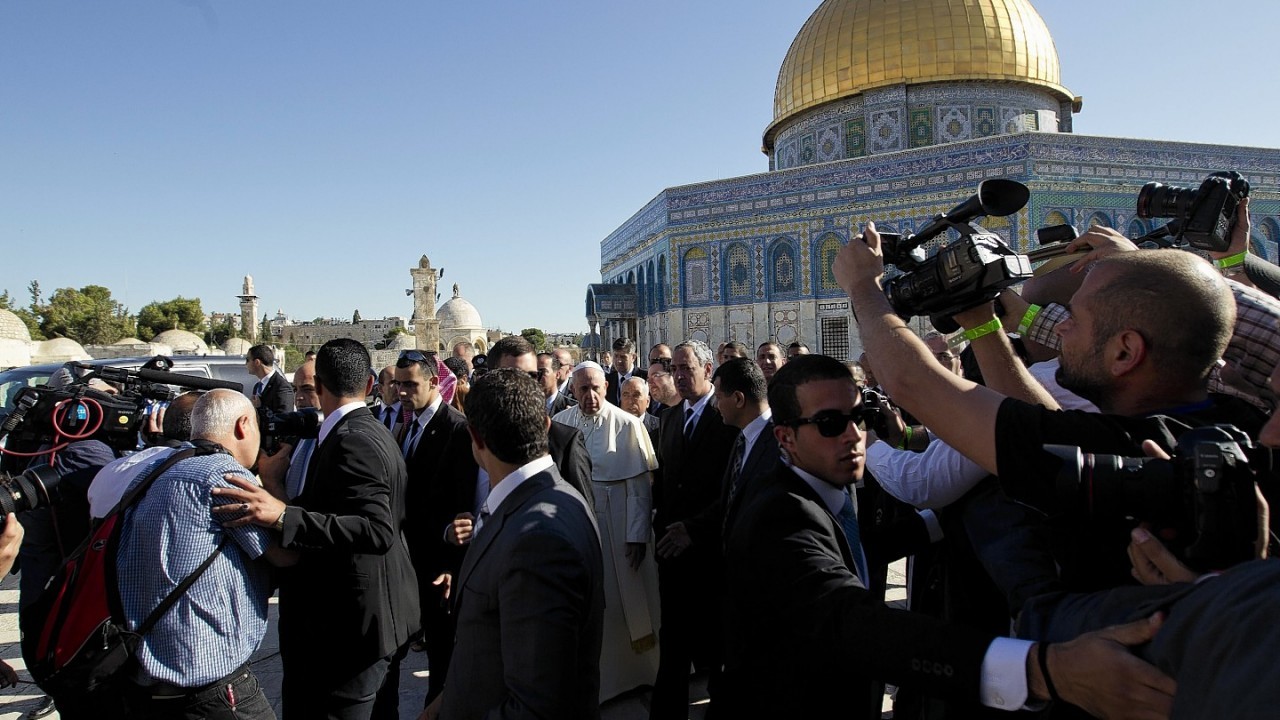 Pope Francis, center, is surrounded by journalists near the Dome of the Rock Mosque