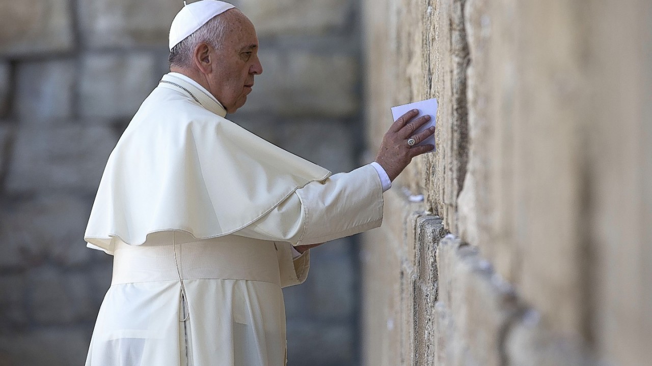 Pope Francis places an envelope in on of the cracks between the stones of the Western Wall, the holiest place where Jews can pray, in the old city of Jerusalem, Israel,