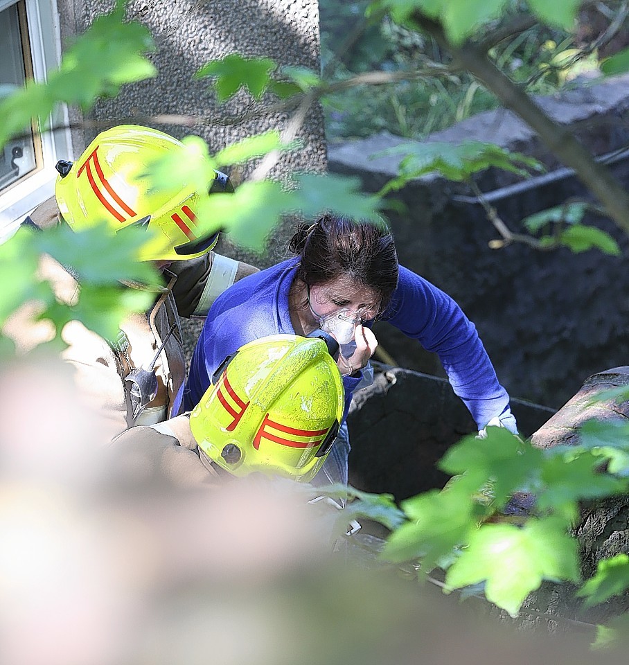 Fire fighters try to comfort Rachel as she inhales oxygen following her ordeal