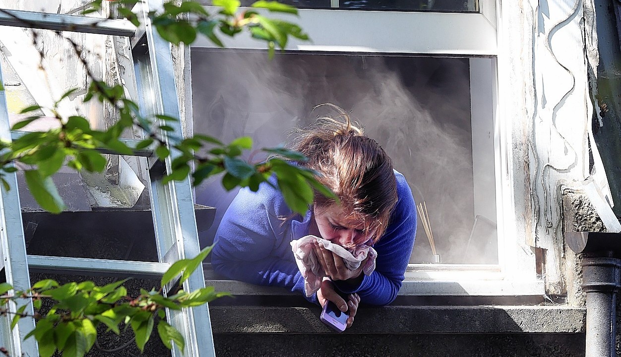 Nurse Rachel Elder gasps for breath as she tries to escape the smoke by leaning out a flat window