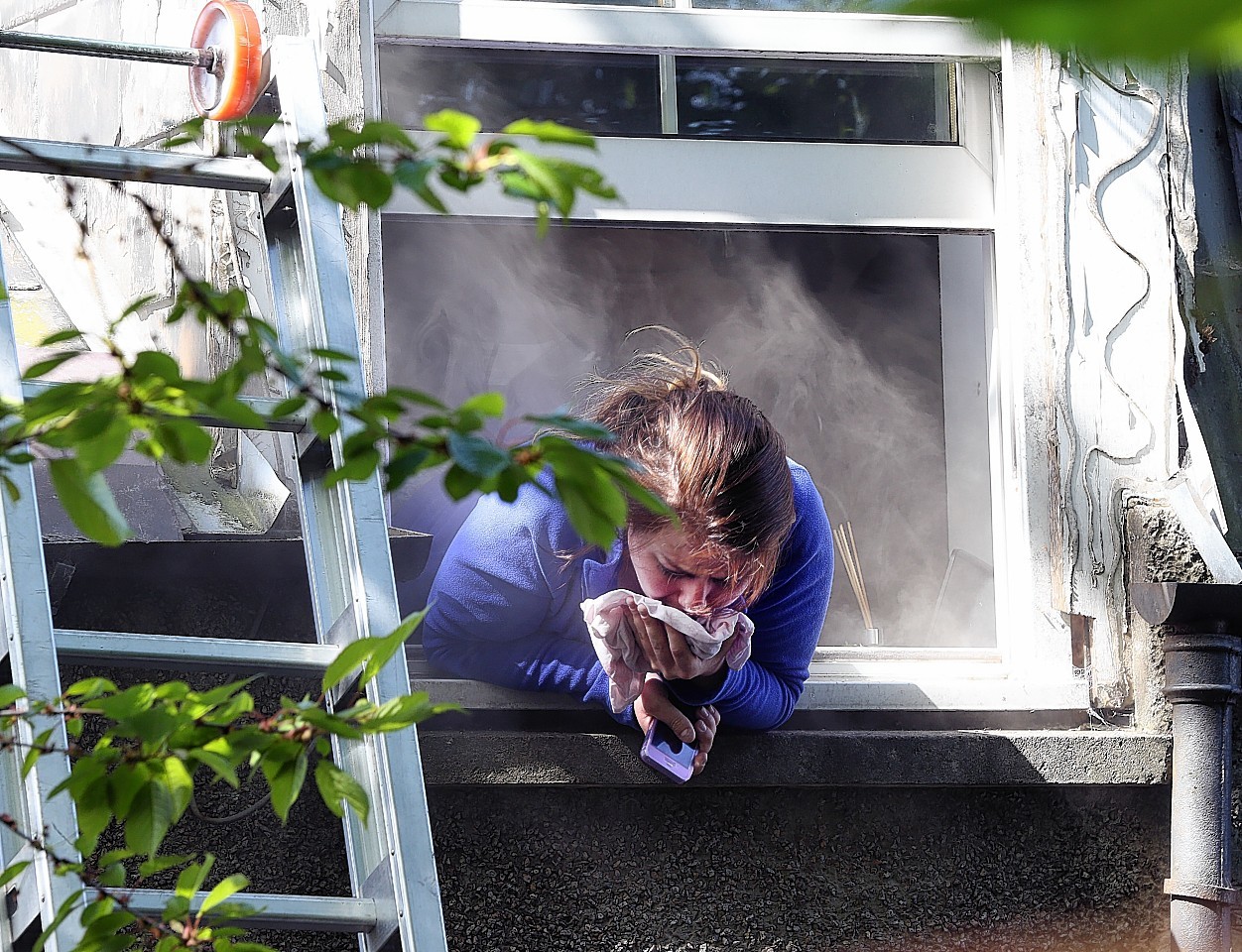 Nurse Rachel Elder gasps for breath as she tries to escape the smoke by leaning out a flat window