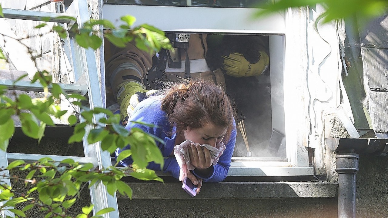 Nurse Rachel Elder gasps for breath as she tries to escape the smoke by leaning out a flat window