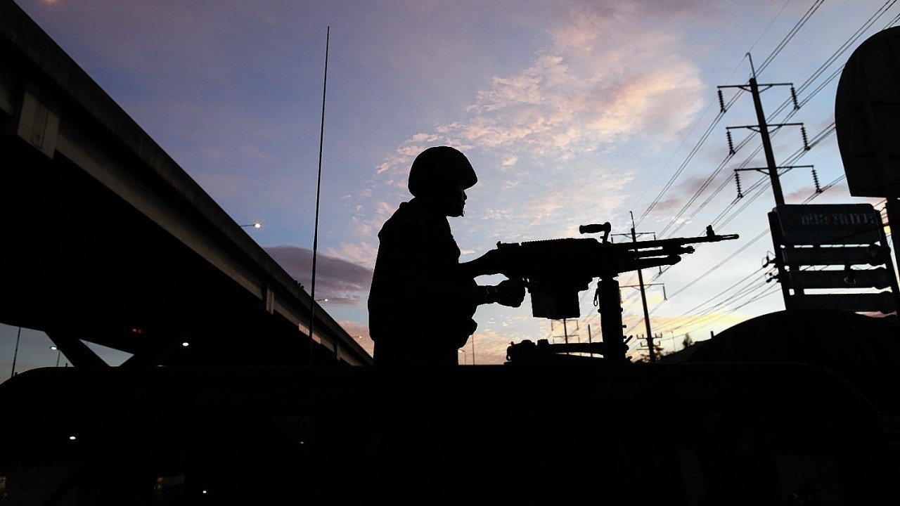 A Thai soldier mans his machine gun atop a military vehicle outside the Centre for the Administration of Peace and Order (CAPO) after soldiers were sent in to seized the center Tuesday, May 20, 2014 in Bangkok