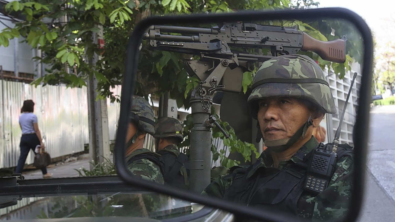 Thai soldiers are reflected in a mirror while guarding the Thai police headquarters Tuesday, May 20, 2014, in Bangkok